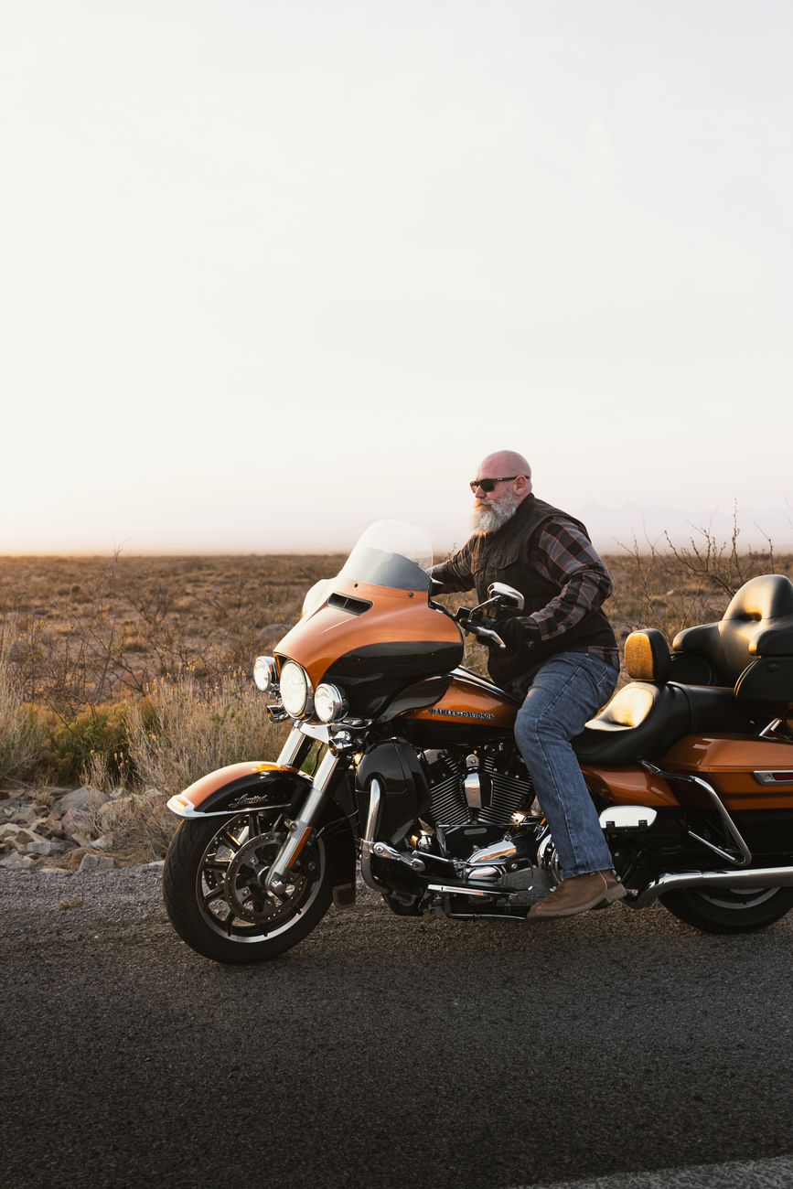 A rider on a Harley-Davidson tourer at sunset